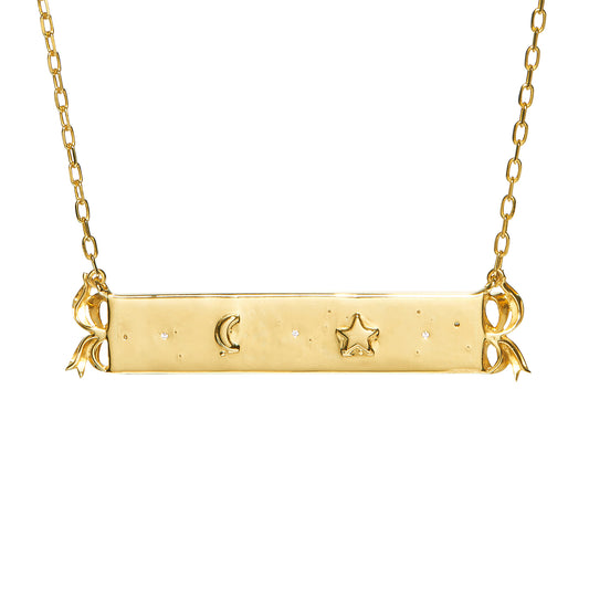 Believe Necklace by Unhada - A one-of-a-kind Unhada creation, this bar necklace reimagines a timeless design with whimsical charm. Crafted in 18k gold, it features the word believe in raised letters, framed by hand-fabricated bows and sparkling diamonds (.15 cts). A tiny star and moon grace the reverse, offering a hidden detail that’s just for you. Thoughtfully designed and expertly crafted, this piece is as meaningful as it is beautiful.