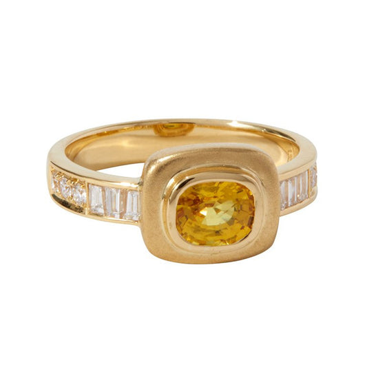 Yellow Sapphire Imperial Ring by Unhada - A ring worthy of an empress, this one-of-a-kind design blends elegance with a touch of mysticism. At its heart lies a vibrant yellow sapphire (.97 cts), framed by baguette and brilliant round diamonds (.62 cts) in a bold 18k gold setting. Perfect for commanding attention or adding a hint of magic to your everyday, this exceptional piece is a true treasure. Size 6.5.