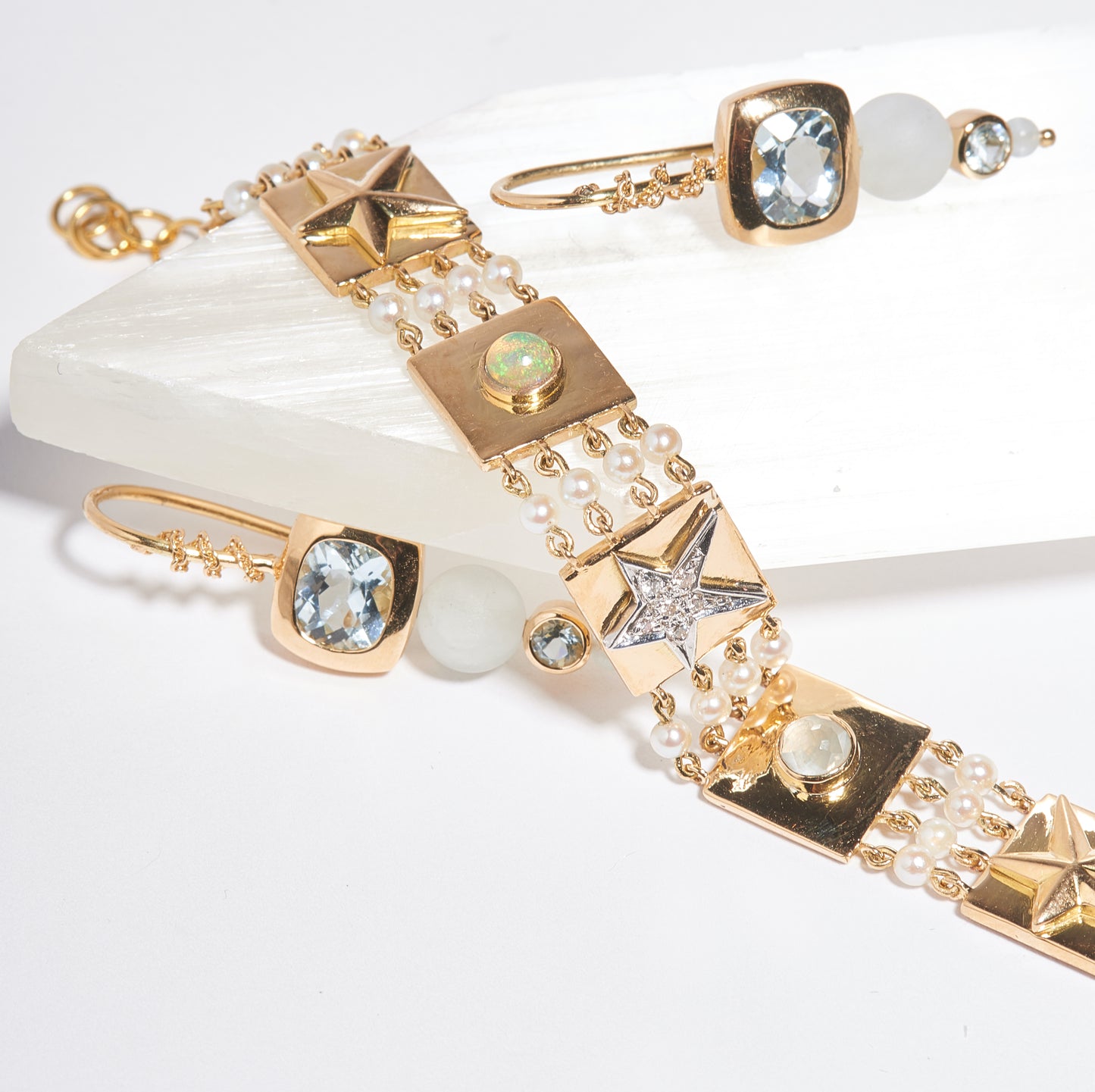 A future heirloom, the one-of-a-kind Capture Bracelet is a testament to extraordinary craftsmanship. Strands of luminous pearls frame a series of 18k gold tiles, each adorned with intricate details: pavé diamond stars (.09 cts), glowing opals, serene aquamarines, and sculpted convex stars. The interplay of textures and gemstones creates a design that feels timeless yet utterly unique. At 6.5” with an adjustable fit, this bracelet is more than a piece of jewelry—it’s a work of art destined to be cherished fo