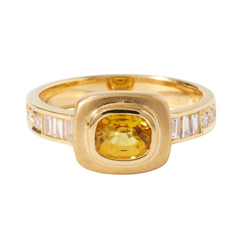 Yellow Sapphire Imperial Ring by Unhada - A ring worthy of an empress, this one-of-a-kind design blends elegance with a touch of mysticism. At its heart lies a vibrant yellow sapphire (.97 cts), framed by baguette and brilliant round diamonds (.62 cts) in a bold 18k gold setting. Perfect for commanding attention or adding a hint of magic to your everyday, this exceptional piece is a true treasure. Size 6.5.